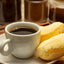 Cup of Café Melitta Extraforte coffee with pao de queijo cheese biscuit