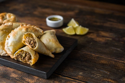 Traditional baked Argentine empanadas savoury pastries with meat beef stuffing and alicante ground cumin