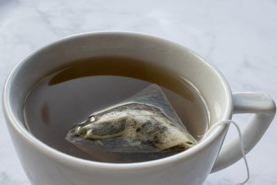 Cup of tea with tea bag on table.