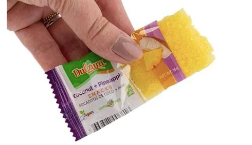 Hand holding open Dulzura coconut pineapple bocaditos snacks