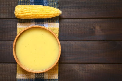 Bowl of Monte Cudine sopa de choclo, instant corn soup and piece of corn on the cob
