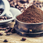 Ground coffee with coffee beans and mug on wood table