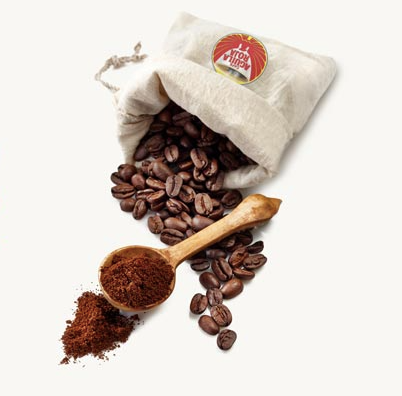 Bag of cafe aguila roja beans with wooden spoon with ground coffee