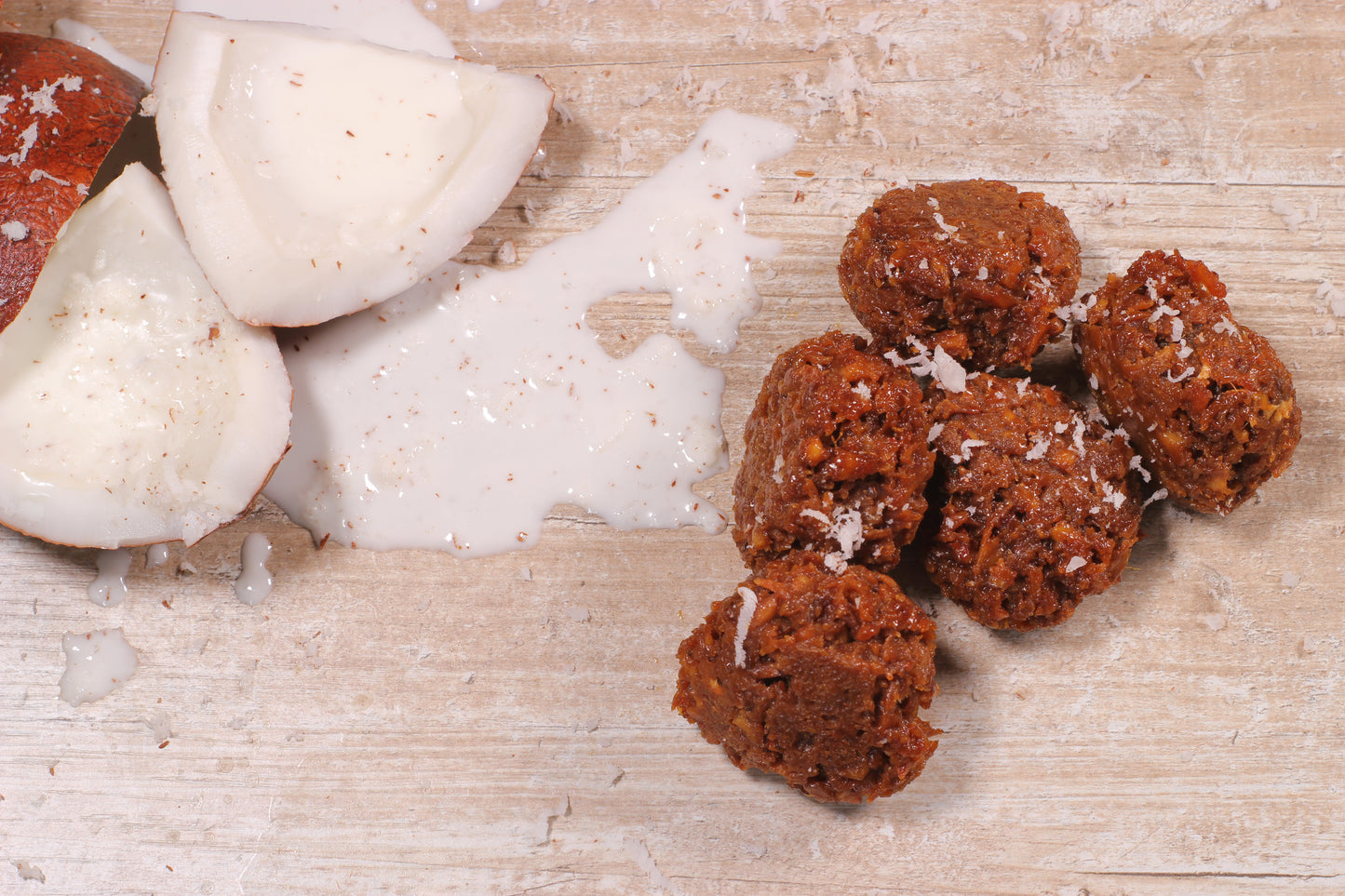 Five coconete coconut cakes with coconut slices and milk on wood table