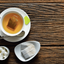 cup of tea with tea bag and sugar cube on wooden table