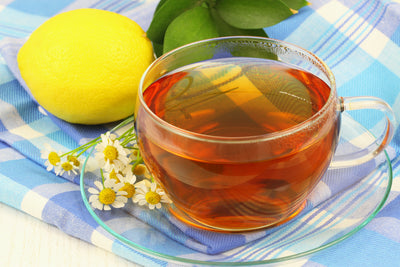Glass cup of digestivo tea with chamomile, mint and lemon